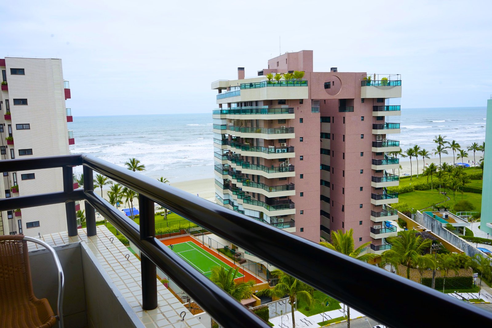 Vista da sacada com vista para a praia e condomínio à beira-mar